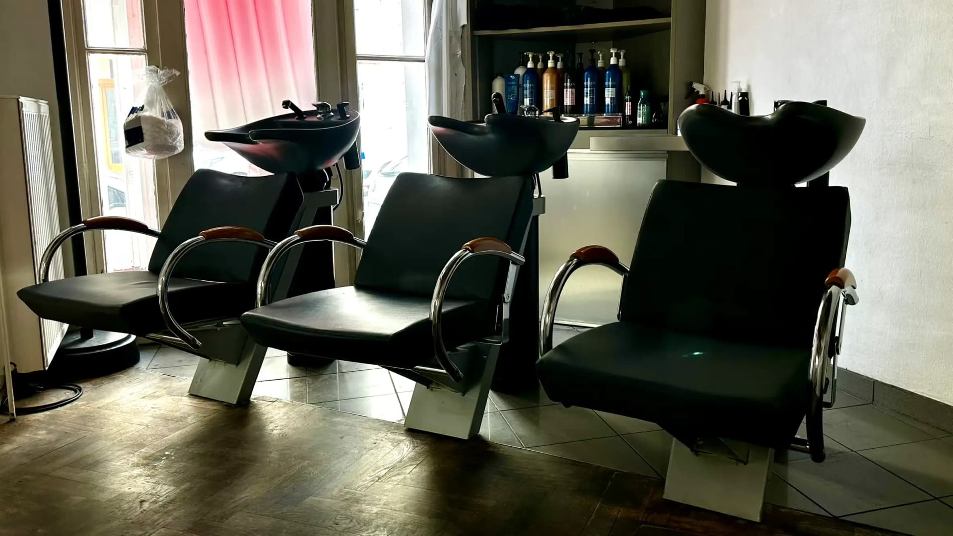 Drei schwarze Waschplätze im Salon von HAIR-FACTORY mit Blick zum Schaufenster.